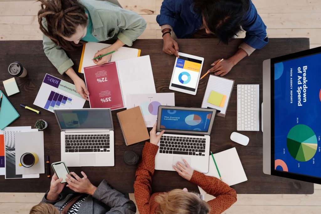 The Art of Drawing Readers In: Your attractive post title goes here A diverse team collaborating on digital marketing strategies at a desk, using laptops and tablets.